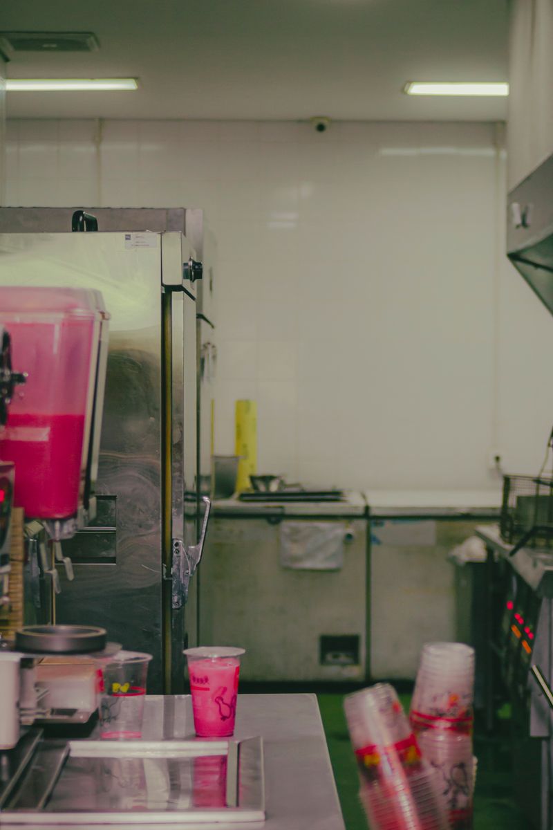 Clean and organized commercial kitchen interior with beverage machines and stainless steel surfaces