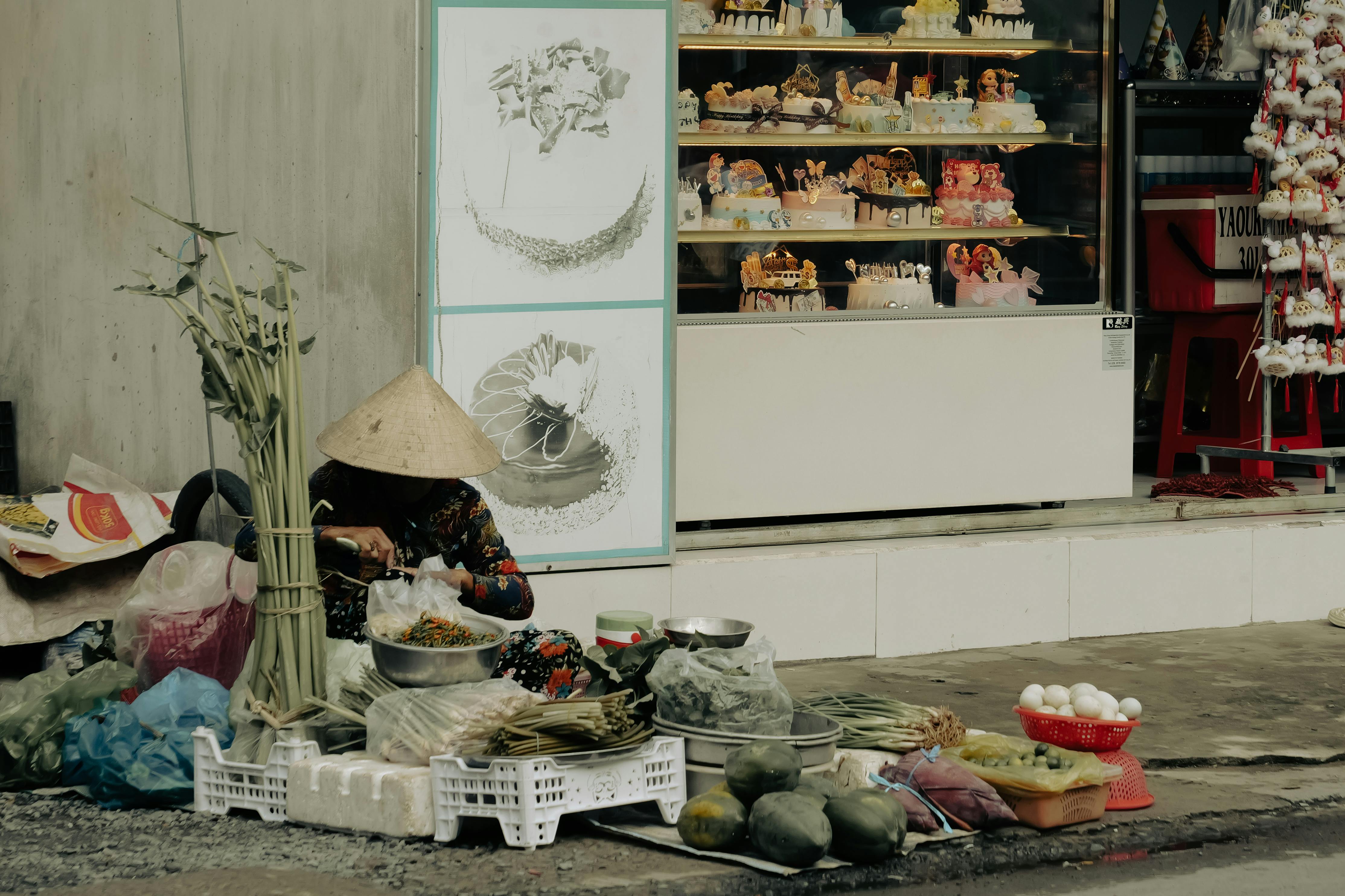 a woman sitting on the ground next to a market