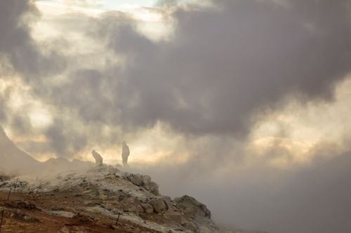 Free Misty mountain scene with silhouettes in dramatic light and foggy atmosphere. Stock Photo