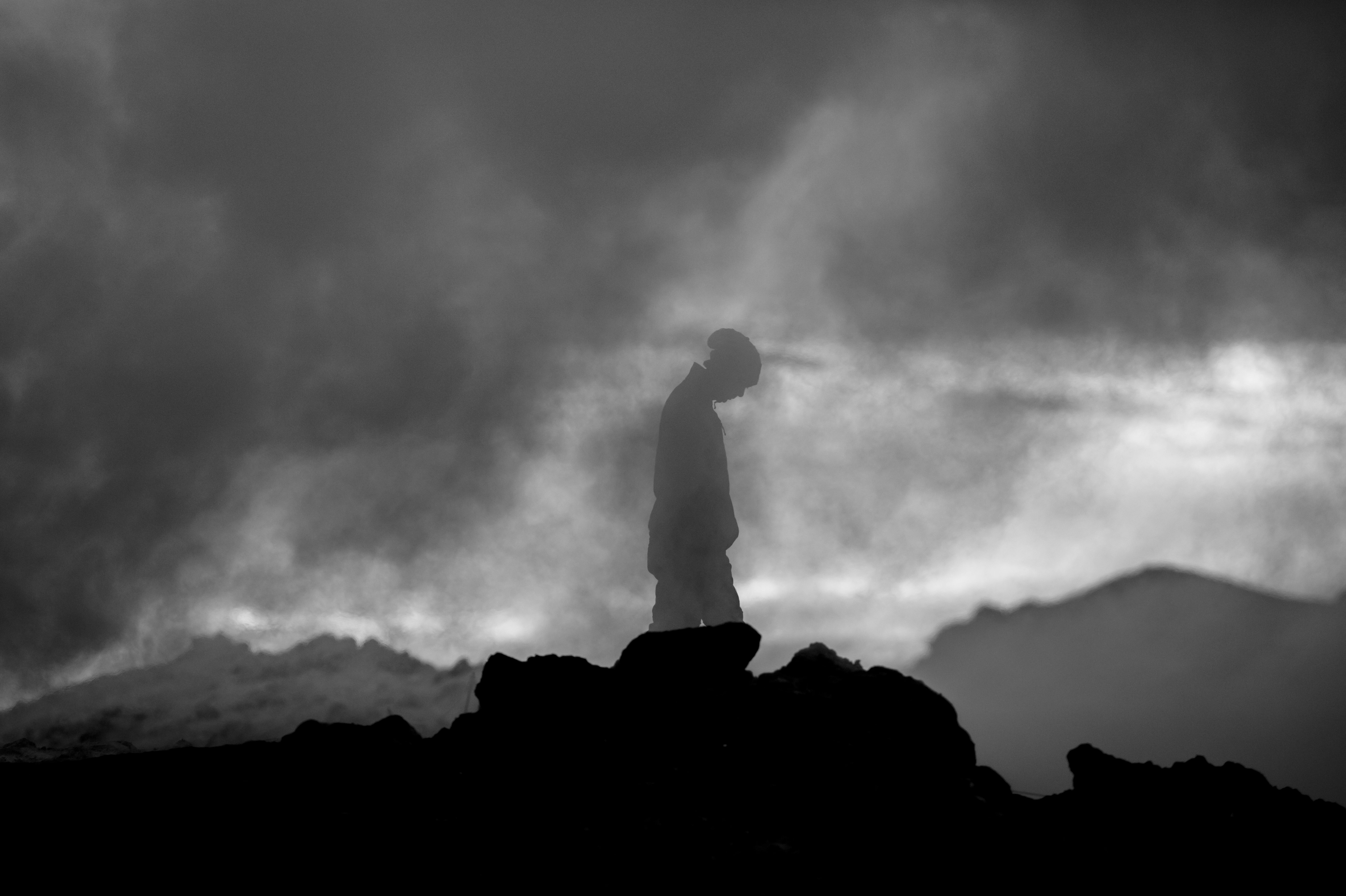 Misty landscape with a silhouetted figure, creating a dramatic and moody atmosphere.