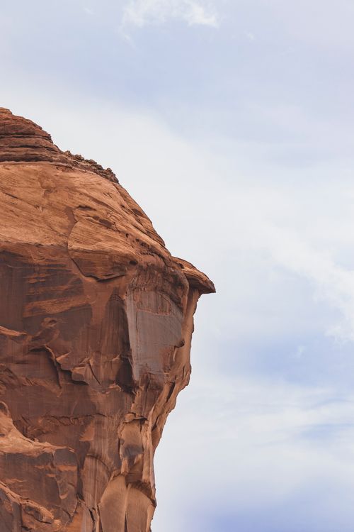 Free A striking sandstone cliff in an arid desert landscape against a clear sky. Stock Photo