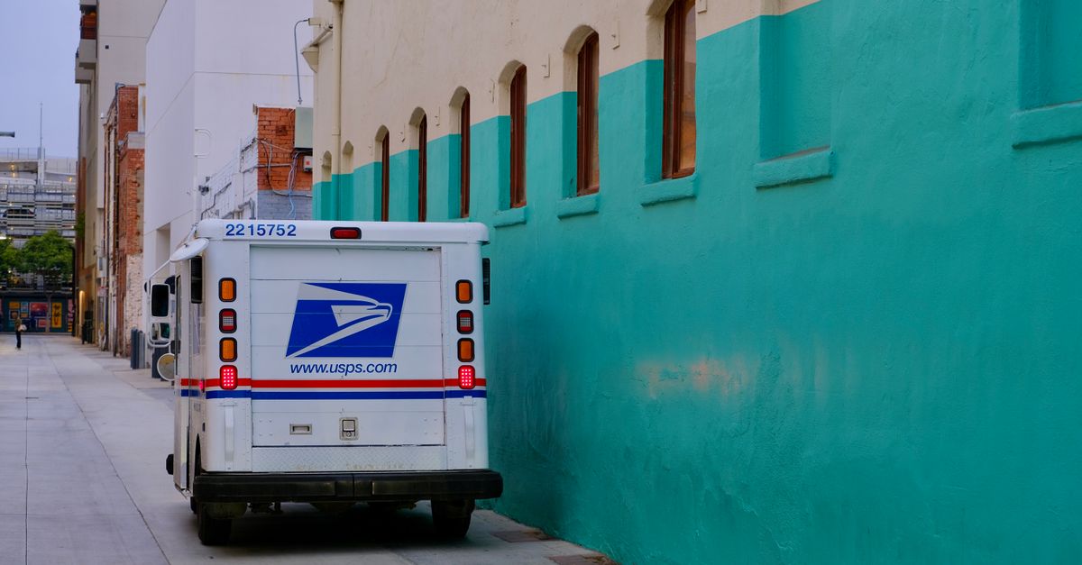 A white USPS postal delivery truck parked on a city street