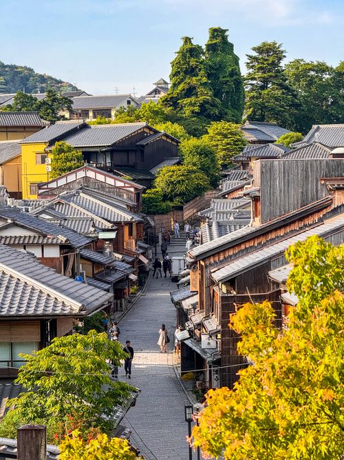 Free Charming view of a historic street in Kyoto, showcasing traditional Japanese architecture and vibrant greenery. Stock Photo