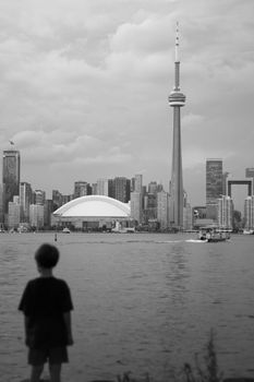 Captivating black and white view of Toronto skyline with CN Tower and water foreground.