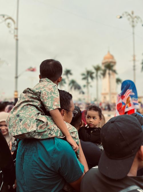 Free A father is carrying his son who is wearing army uniform during Malaysian independence Day Stock Photo