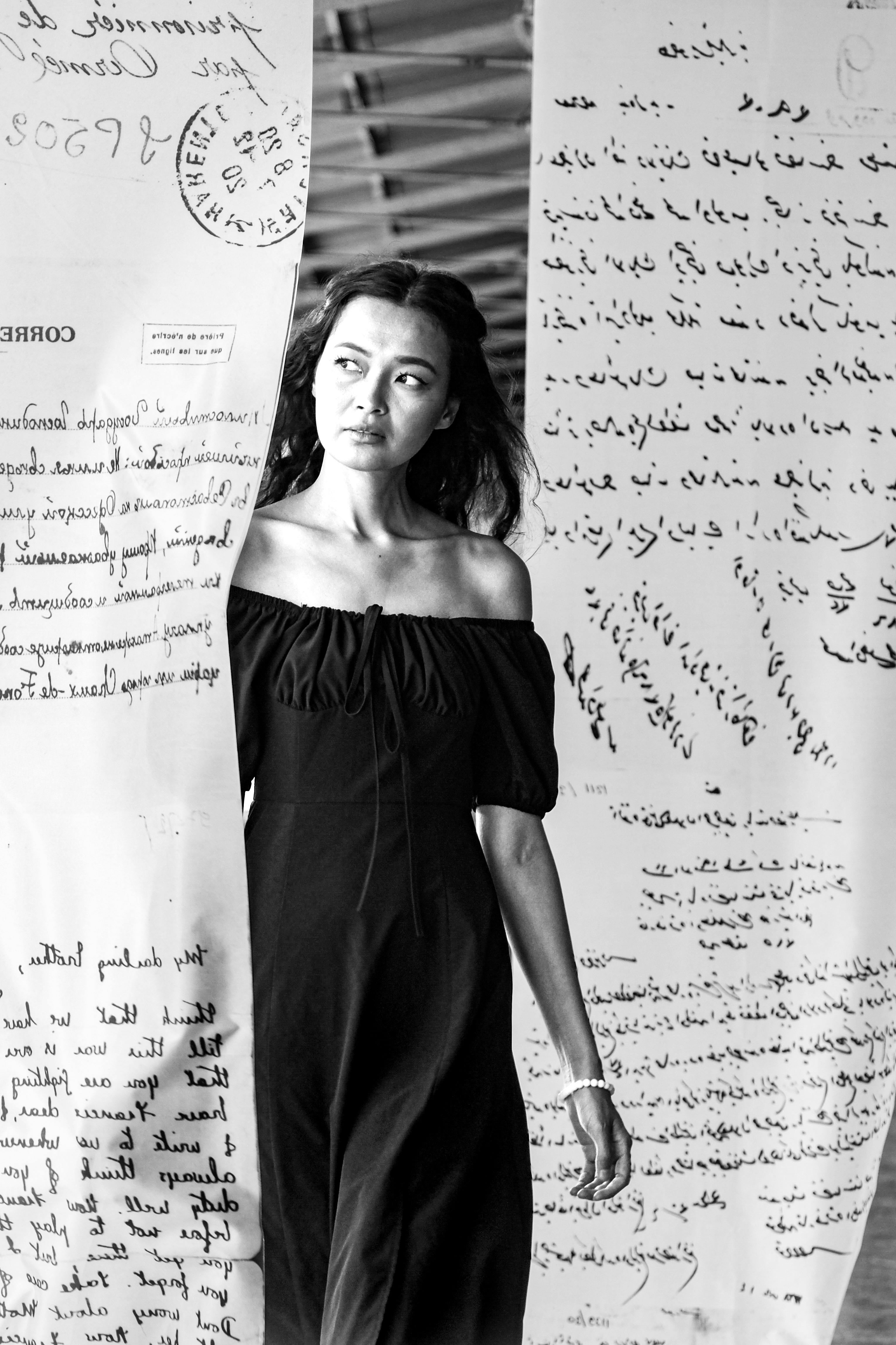 Black and white photo of a woman amidst artistic letter installation in Istanbul.