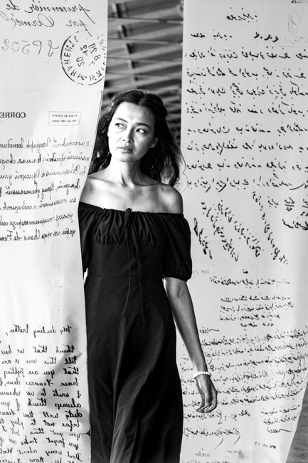 Black and white photo of a woman amidst artistic letter installation in Istanbul.