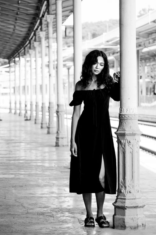 Free Stylish woman in black dress poses at historic Istanbul train station in black and white. Stock Photo