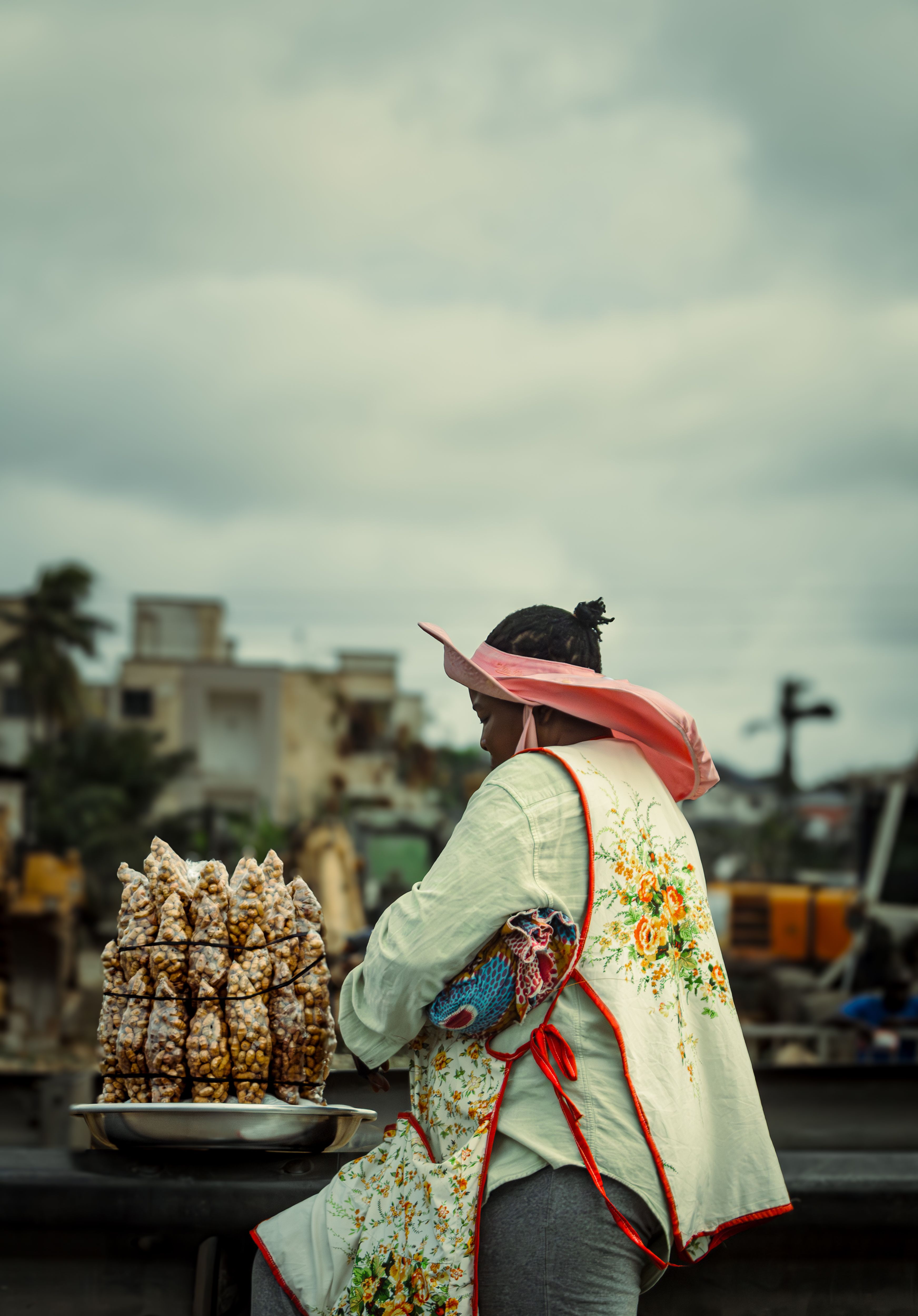 A woman in Accra, Ghana, selling traditional snacks on a bustling street.