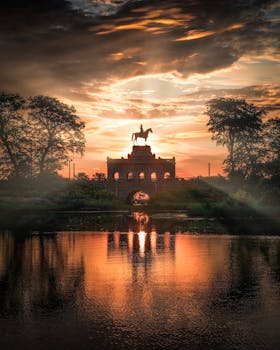 马术雕像的轮廓在充满活力的日落和水面倒影映衬下，显得格外令人惊叹