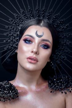 Captivating studio portrait of a woman with artistic crescent makeup and glamorous accessories.