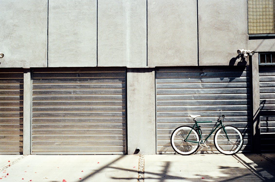 Free Green Bike Near Roll-up Door Stock Photo