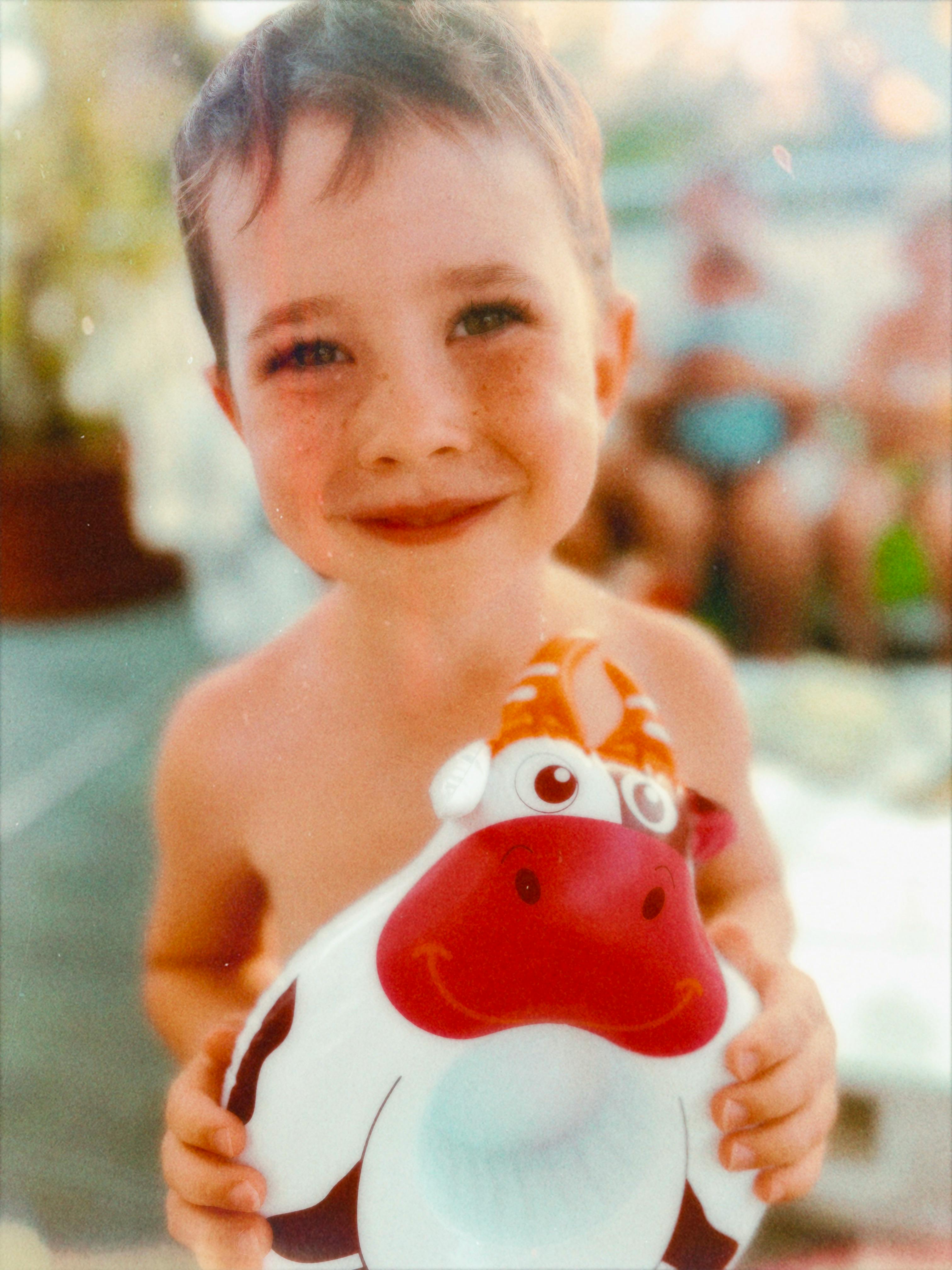 a young boy holding a toy cow