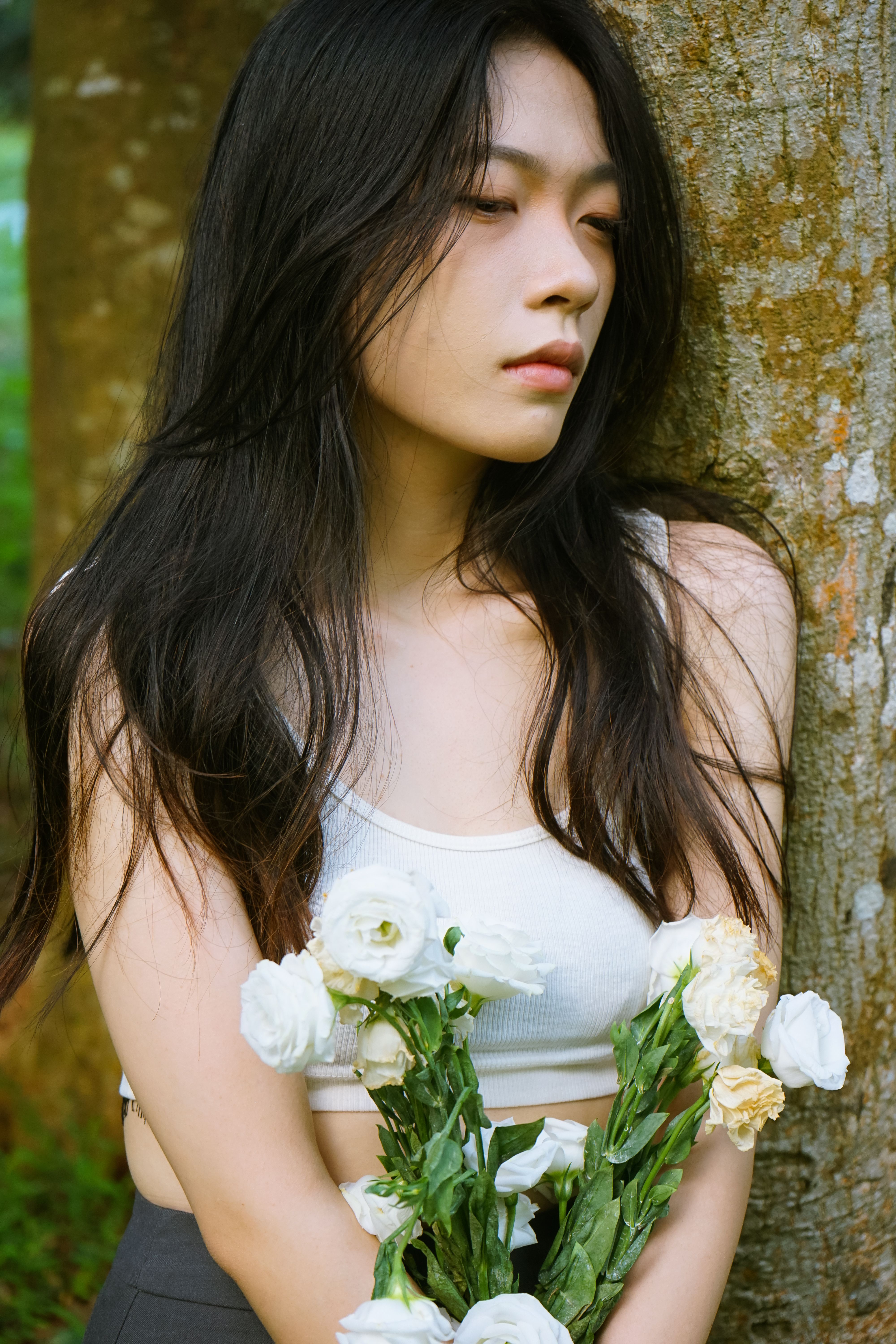 A woman with long hair and flowers in her hands · Free Stock Photo