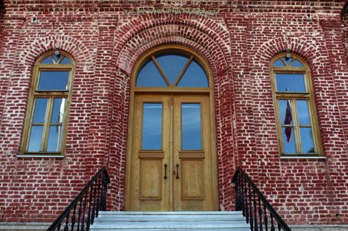 Free Detailed view of a historic red brick facade with arched doorway and windows in Zeytinburnu, Istanbul. Stock Photo