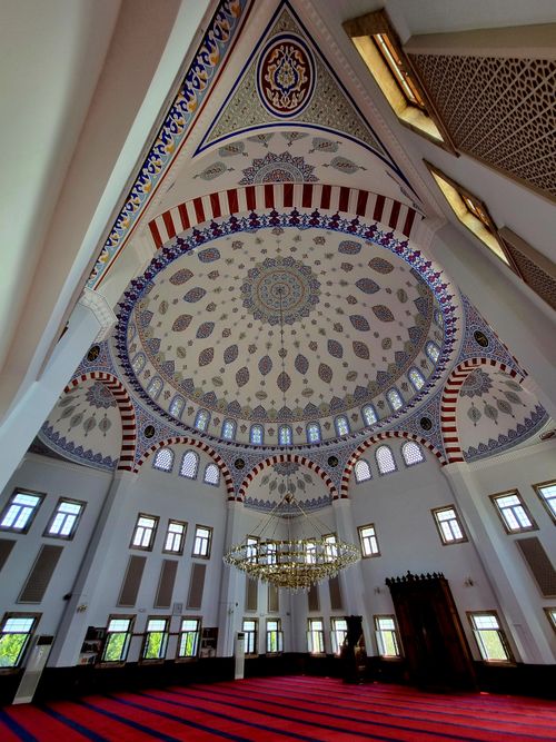 Free Stunning architectural details of a mosque interior with an ornate dome and elegant chandelier. Stock Photo