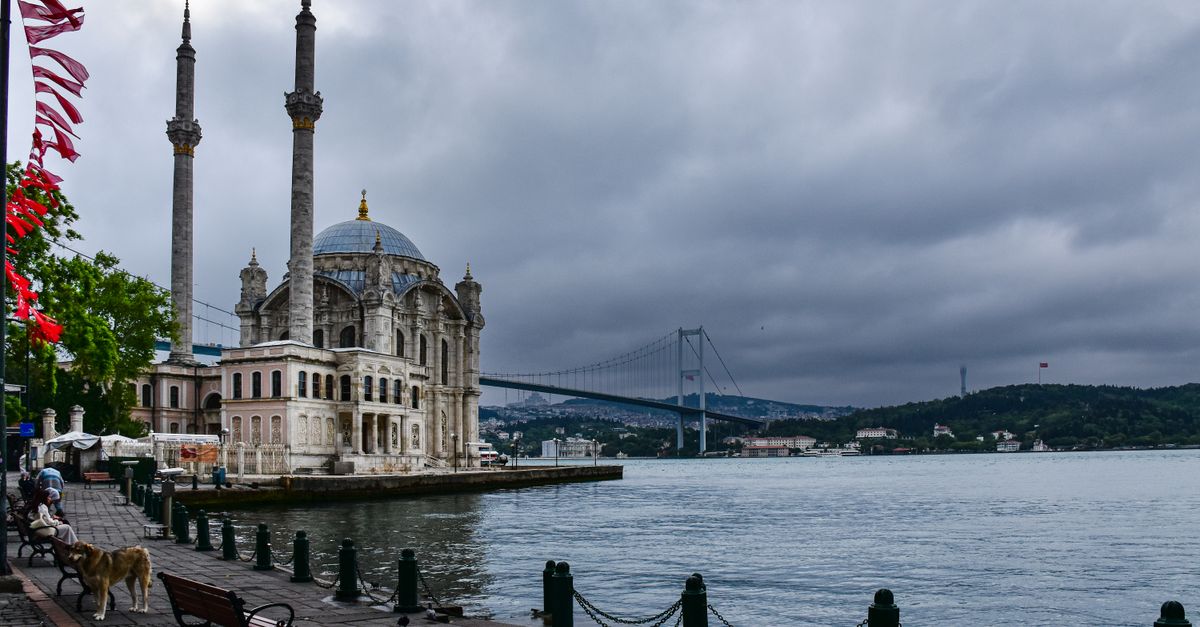 A view of a mosque and a bench on the water · Free Stock Photo