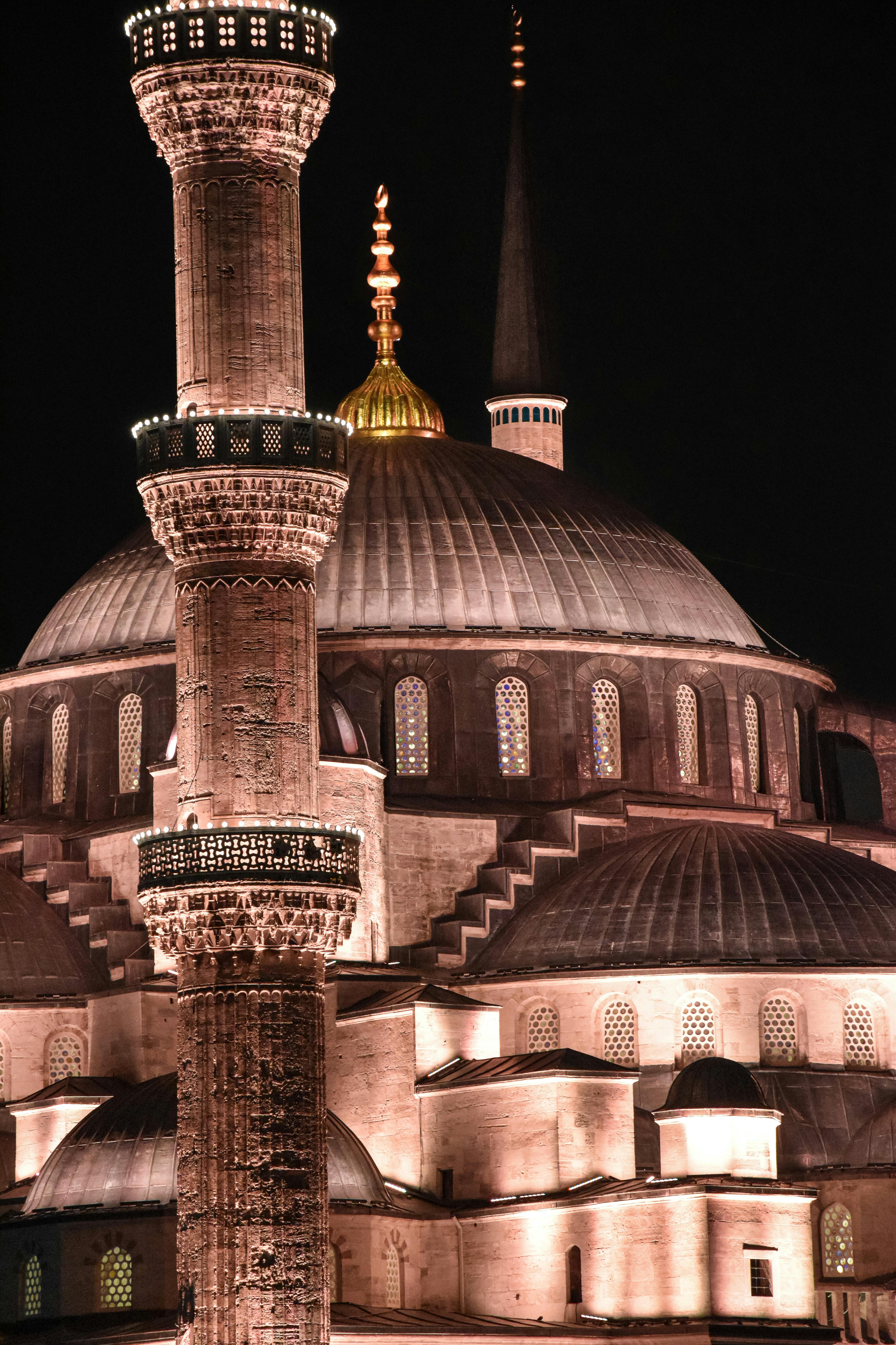 the blue mosque at night with the minarets lit up