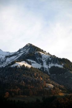 Breathtaking view of snowy Swiss mountain peaks and forests in Sarnen.