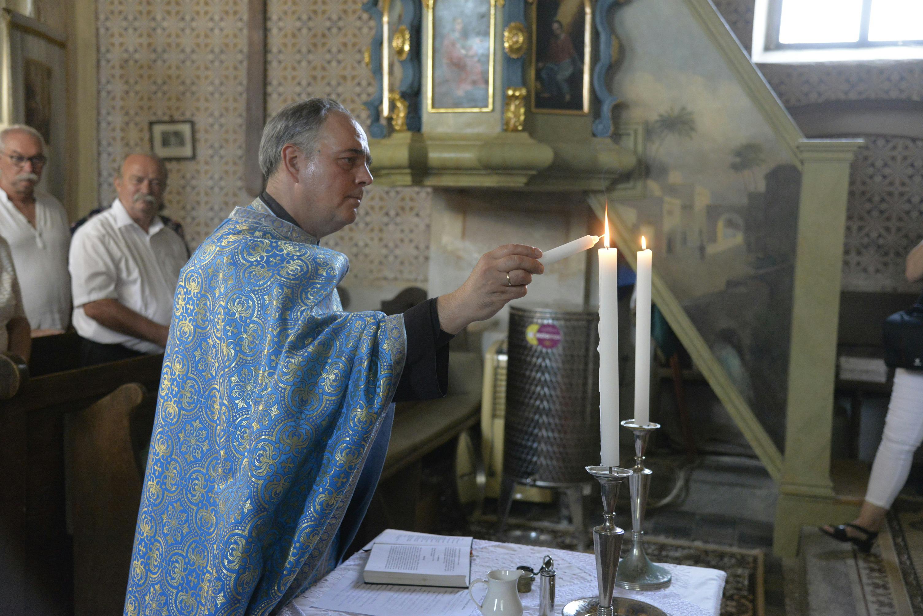 Sacerdote a acender velas na igreja - tradições sagradas católicas