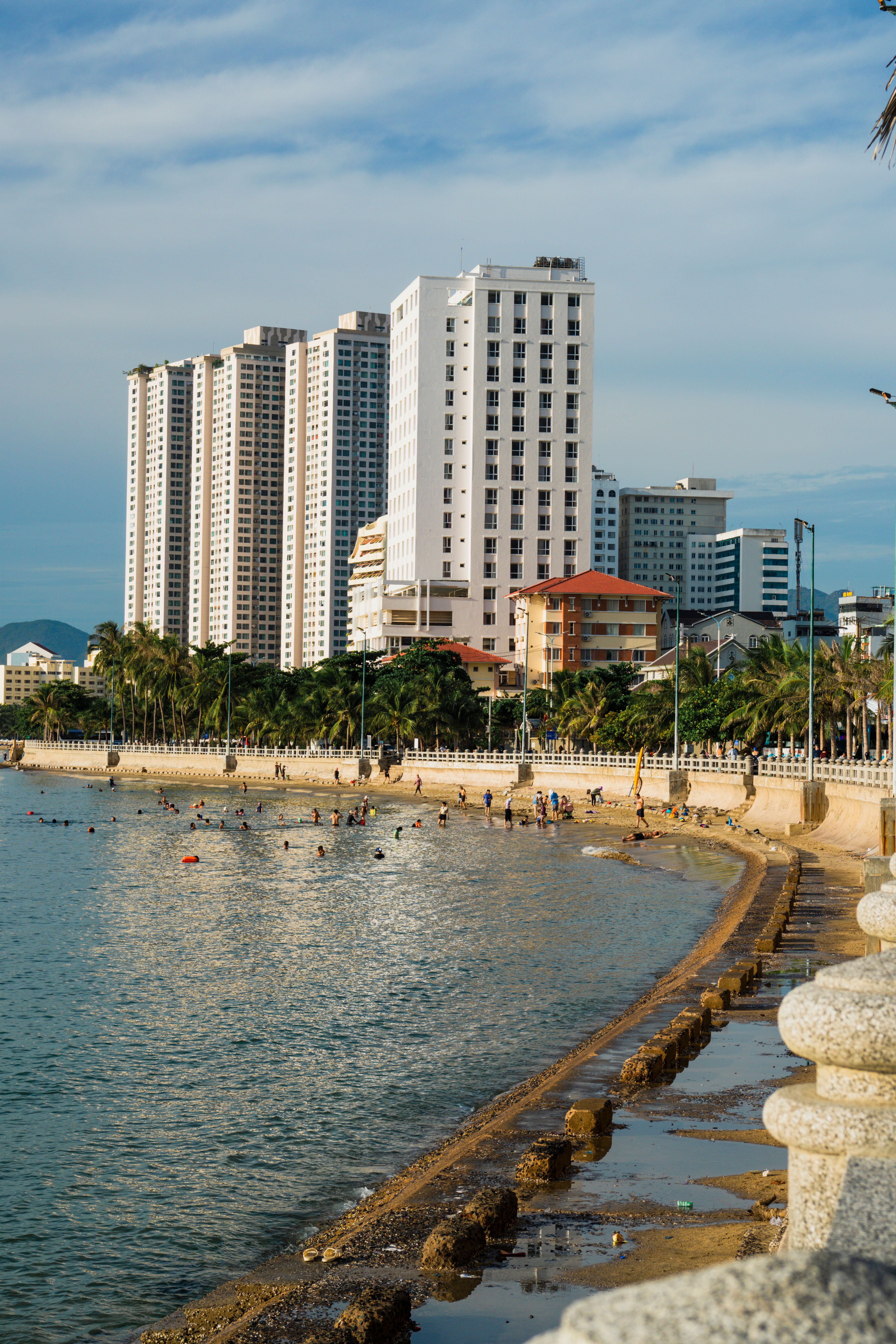 A beach with buildings in the background and people walking · Free ...
