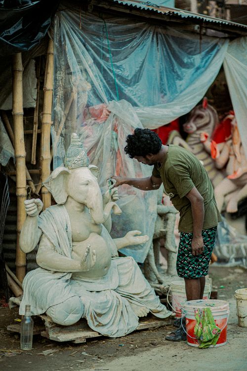 Free An artist meticulously crafts a Ganesh statue in Lucknow, India, showcasing traditional artistry. Stock Photo