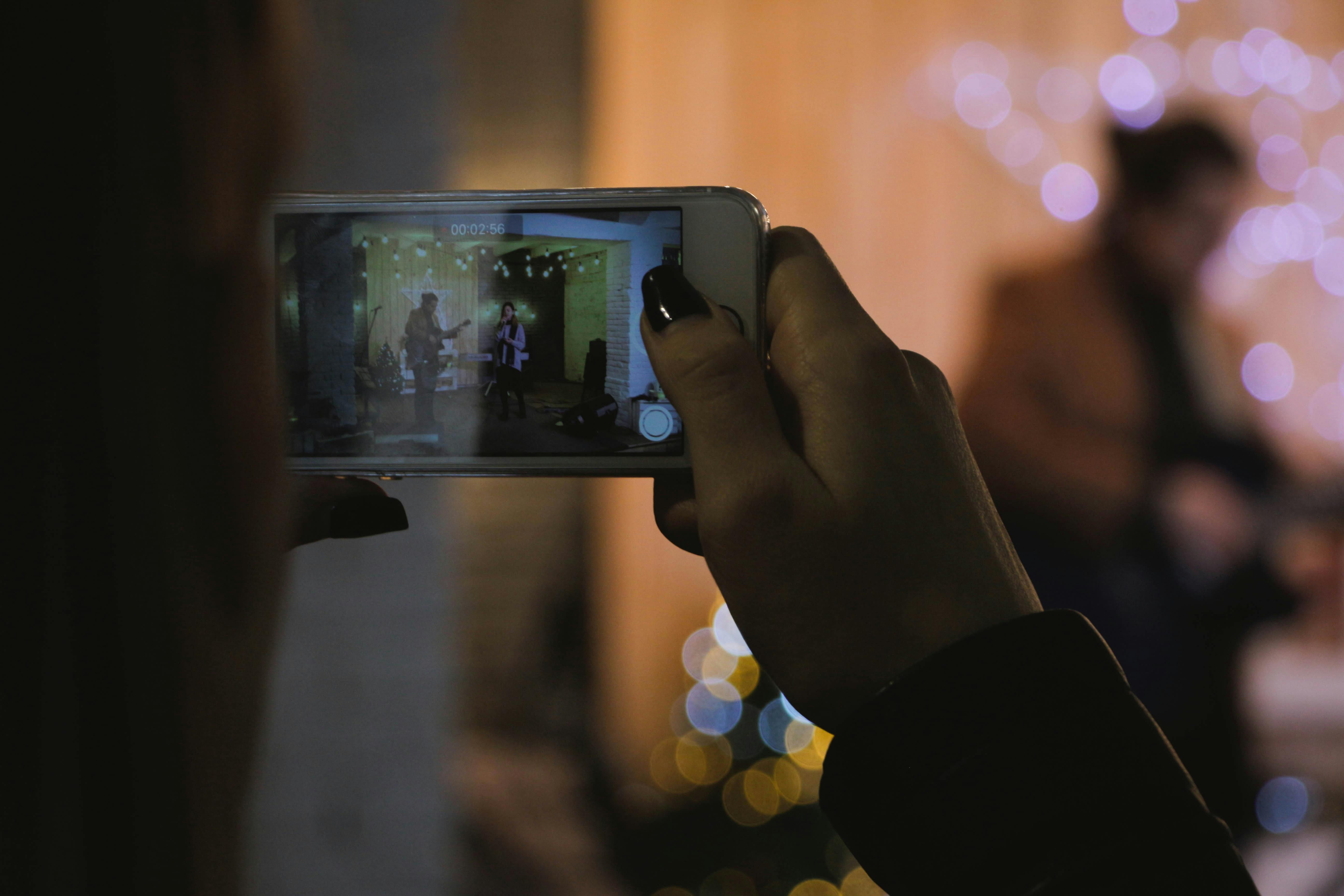 shallow focus photography of person holding silver iphone