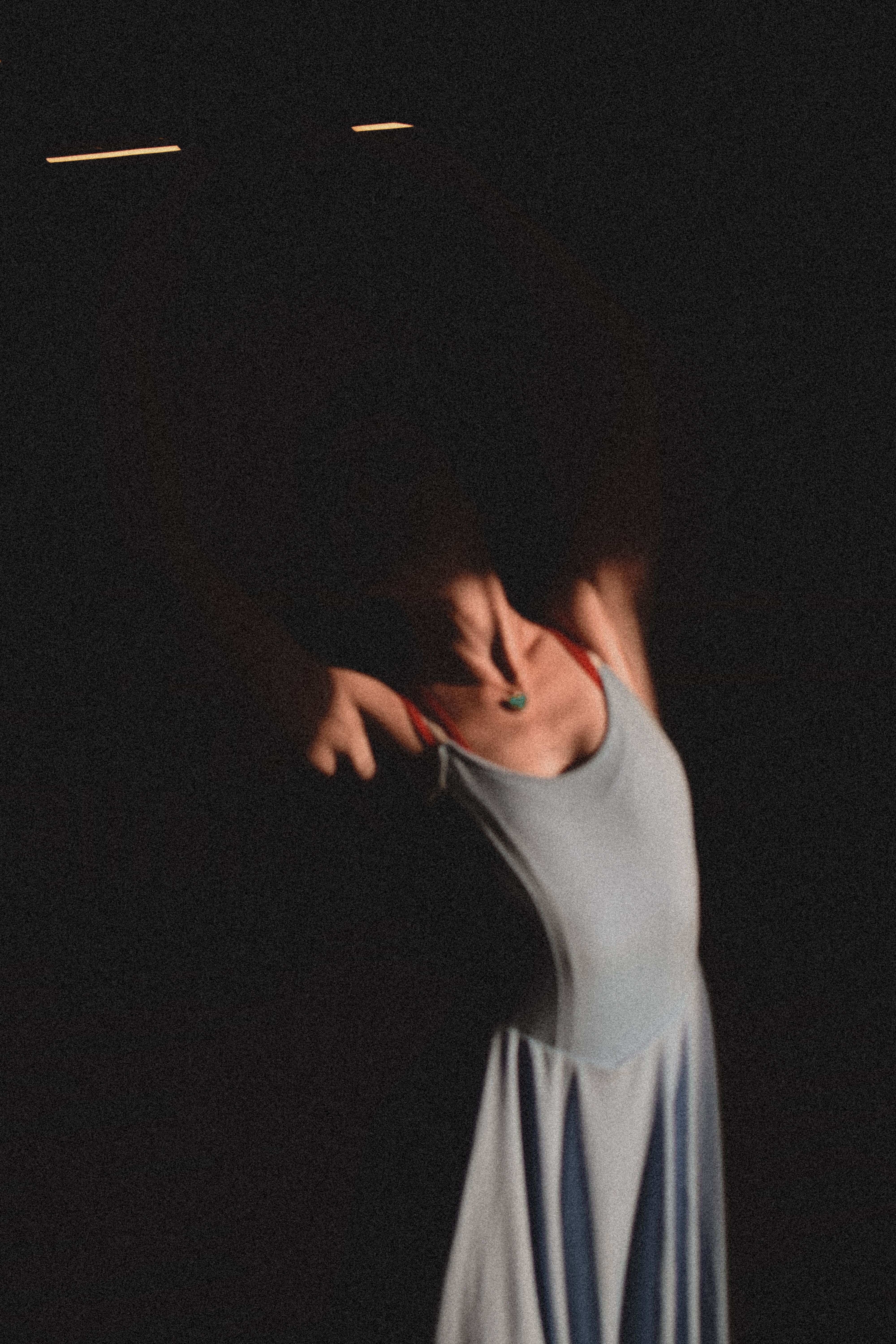 A woman in a blue dress is standing in the dark · Free Stock Photo