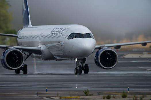 Close-up of Aegean Airlines Airbus preparing for takeoff on a foggy runway in Madrid.
