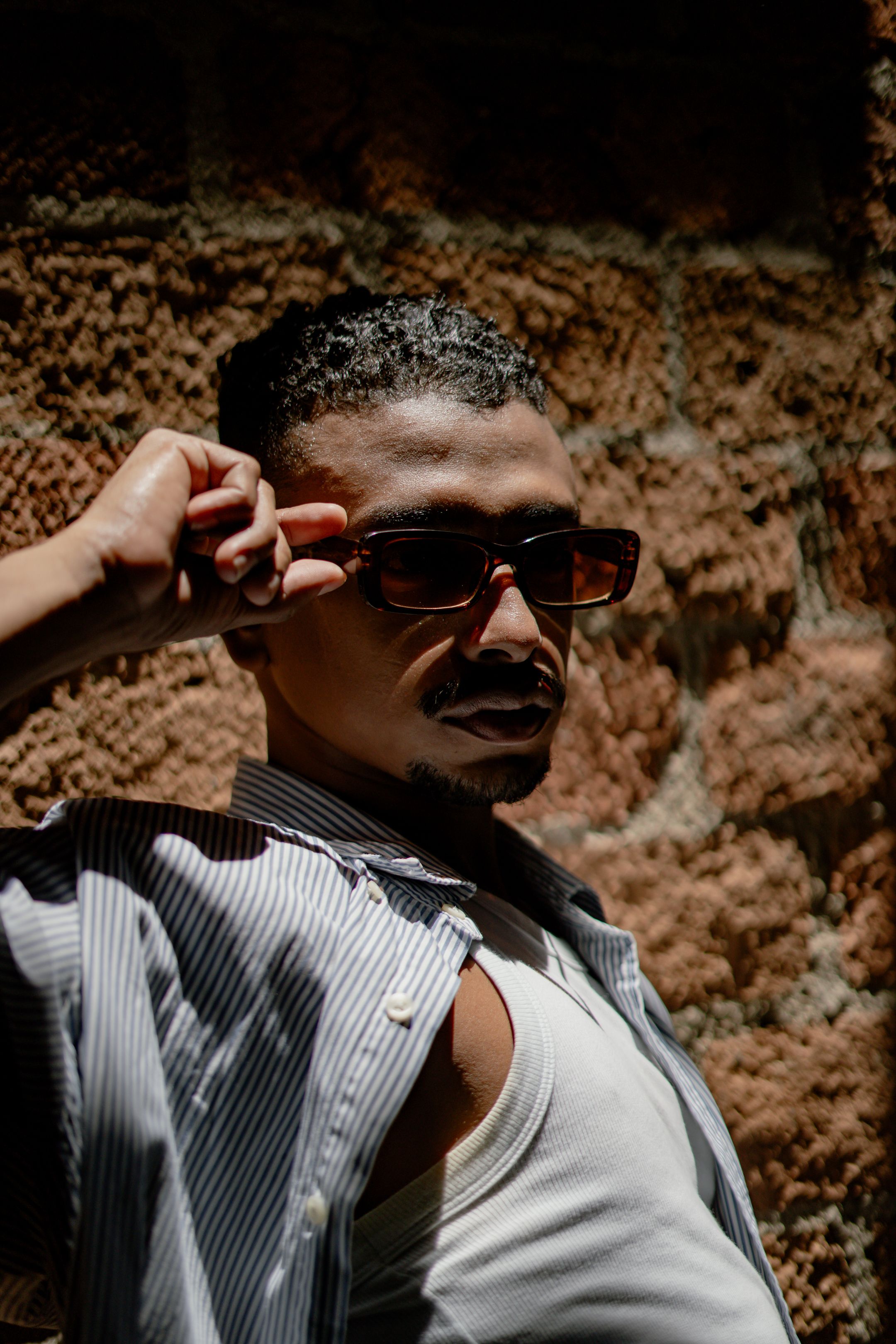 Stylish Man in Sunglasses Against Brick Wall · Free Stock Photo
