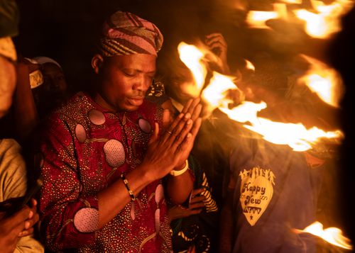 Free A man in traditional attire at a fire-lit ceremony in Osun, Nigeria. Stock Photo