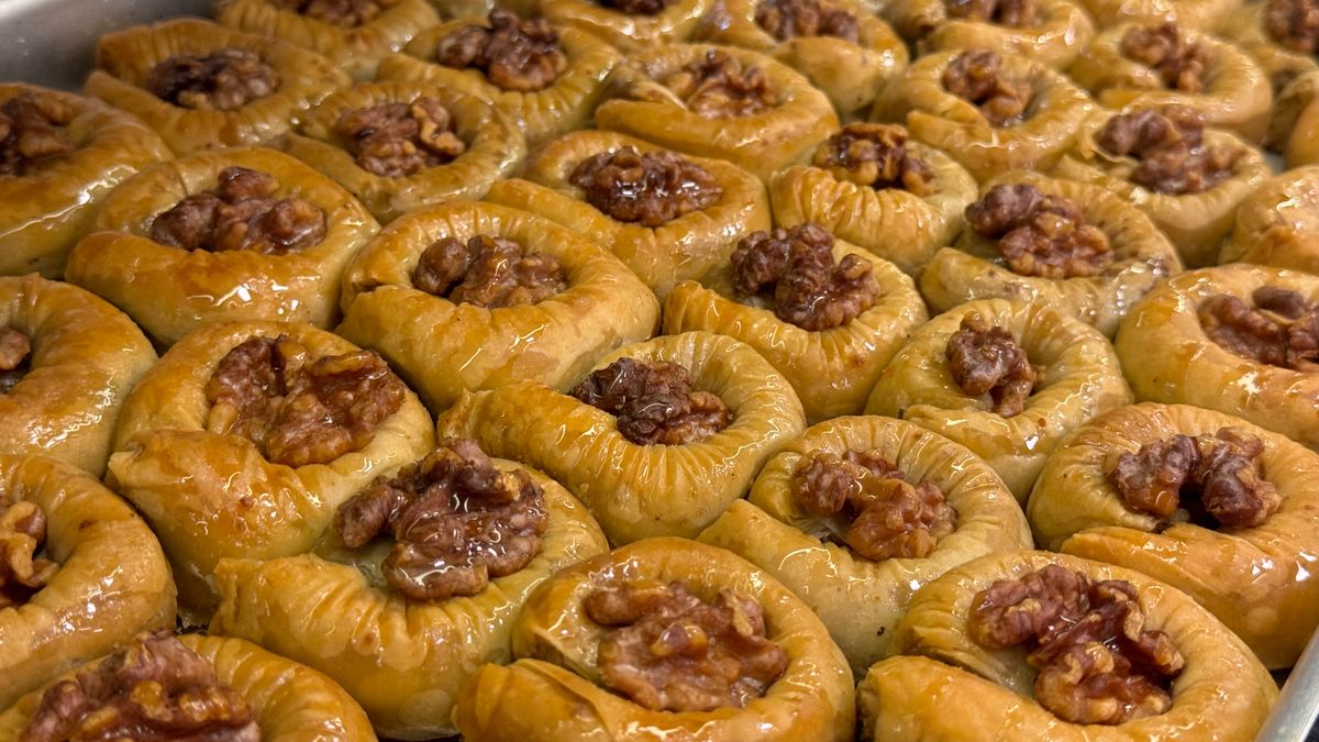 Close-up view of walnut-filled baklava pastries, showcasing rich textures and sweet glaze.