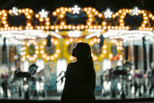 Free Nighttime silhouette of a woman in front of a brightly lit carousel in Veracruz, Mexico. Stock Photo