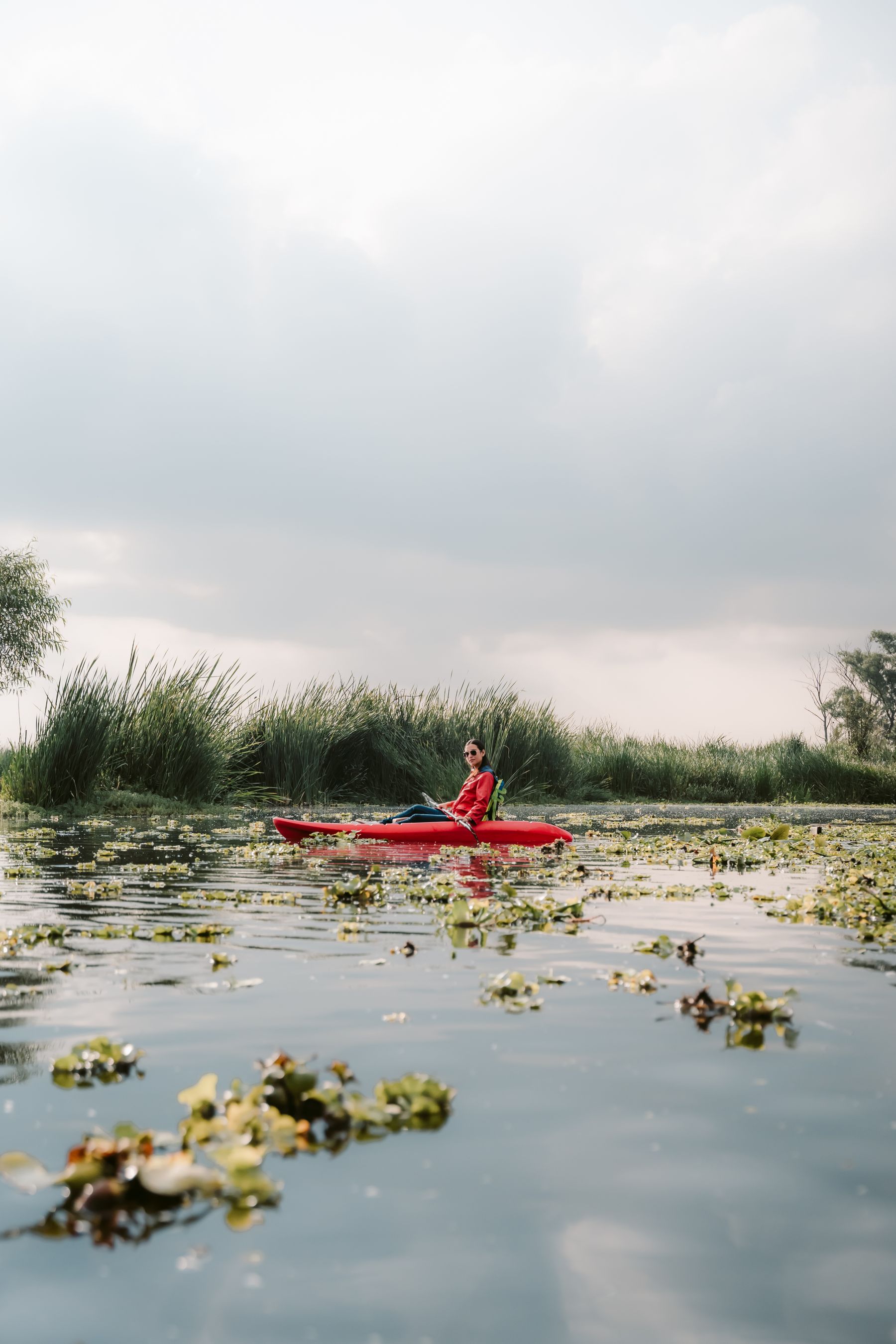 Paddler exploring a calm lake surrounded by natural vegetation