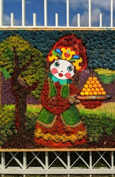 Vibrant outdoor mural with a whimsical figure amidst colorful foliage.