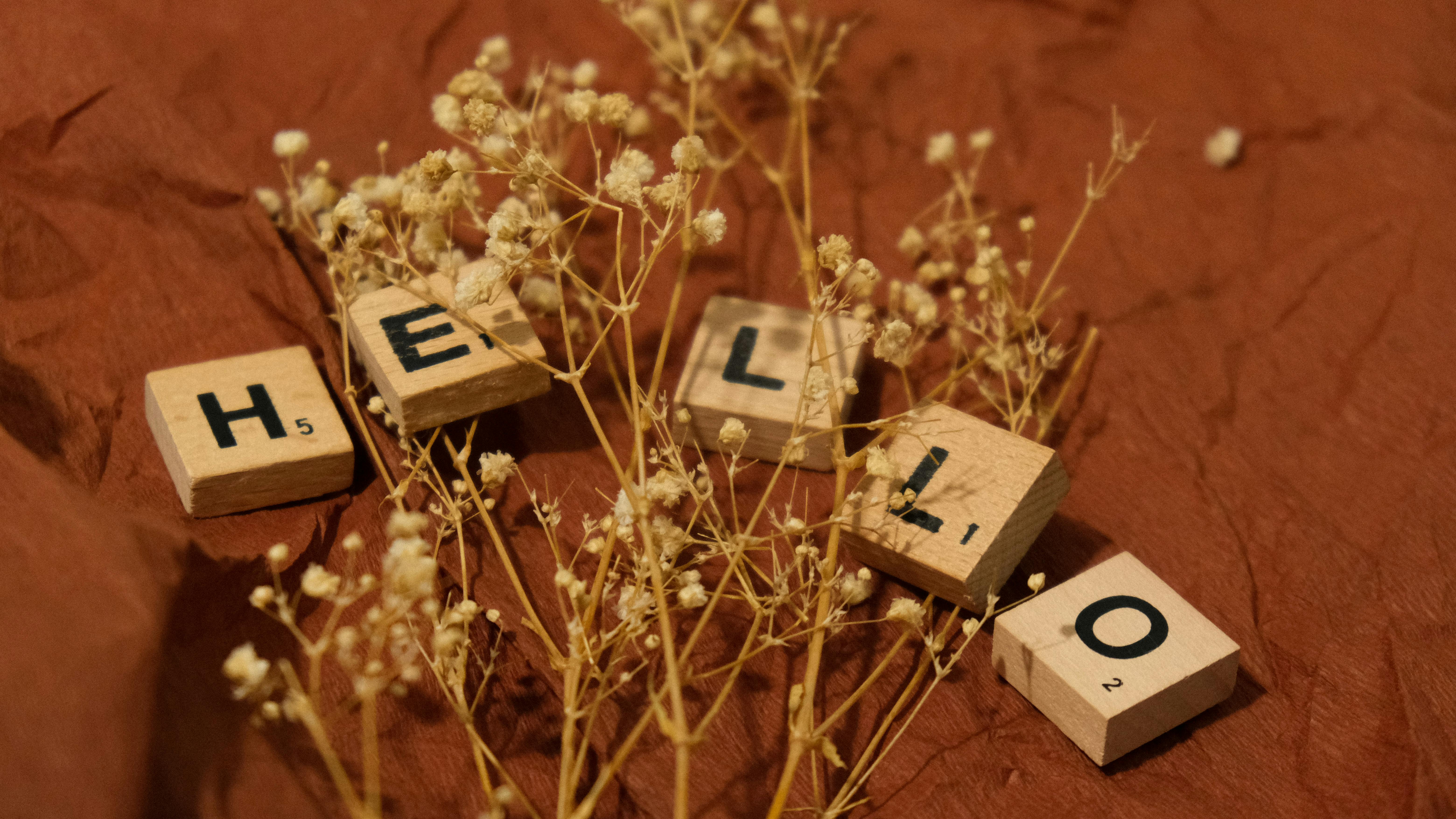 a wooden block with the word hello and flowers