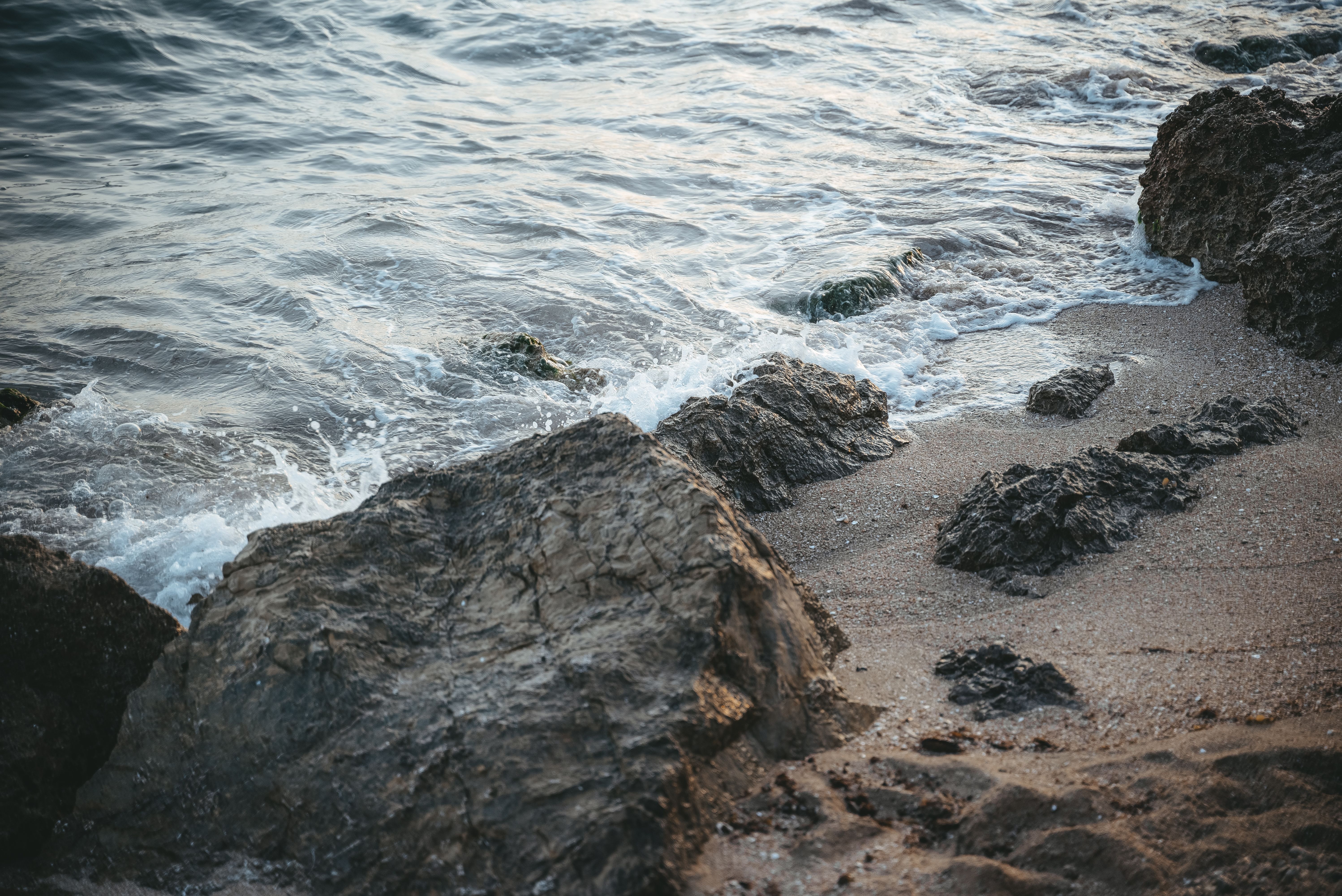 A beach with rocks and water · Free Stock Photo