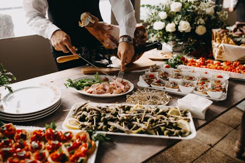 Persona In Piedi Utilizzando Forchetta E Coltello Sulla Preparazione Del Cibo