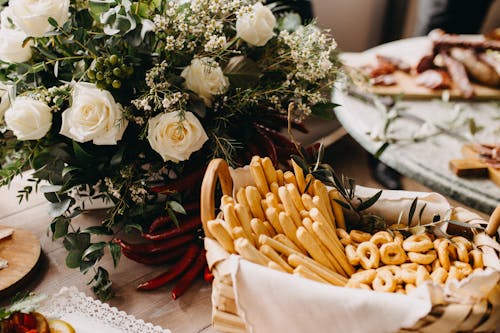 テーブルの上の食べ物の横にある白い花びらの花