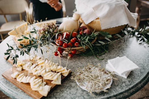 Serving of sliced cheese and cherry tomatoes on a marble table with fresh herbs.