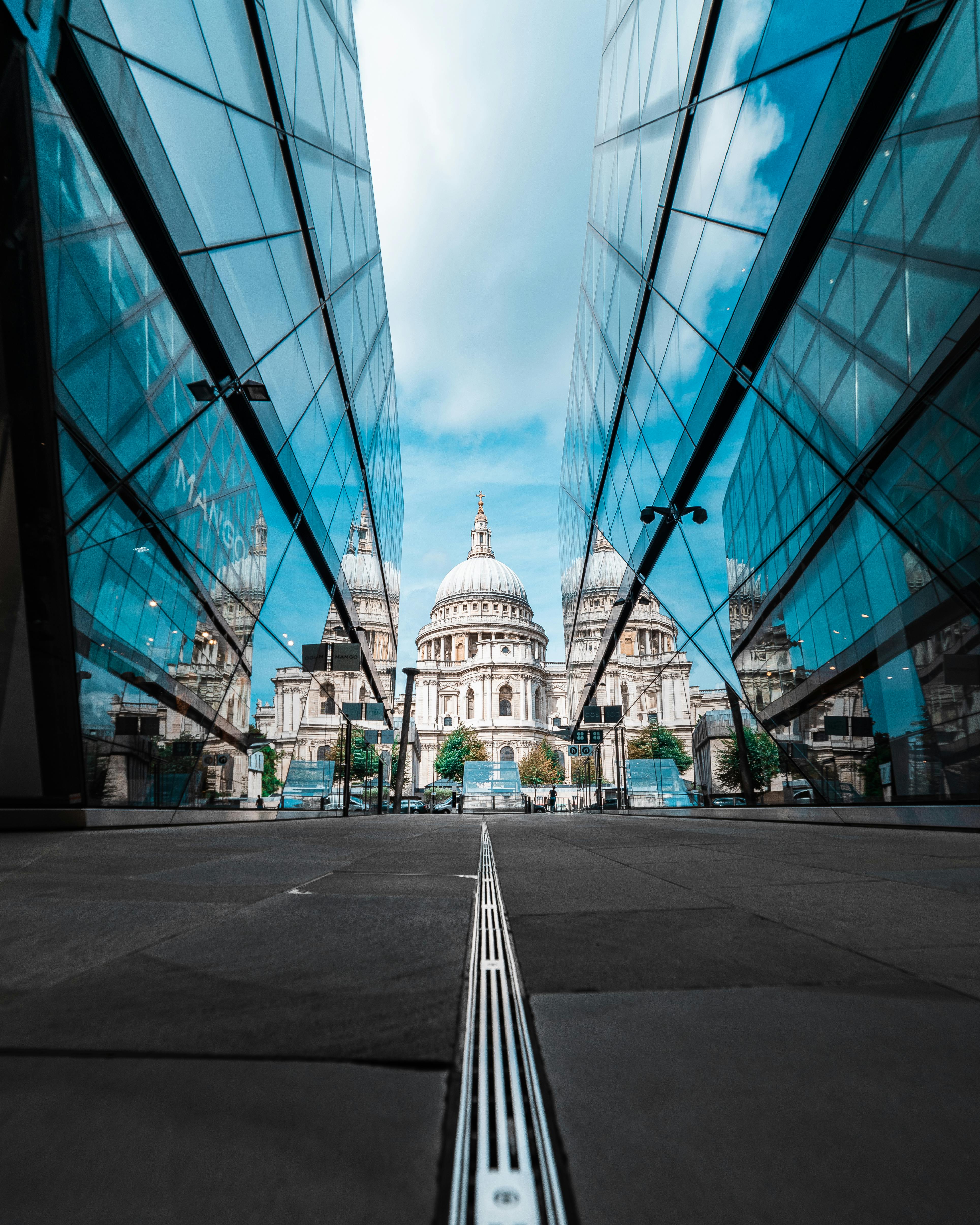 low angle shot of st paul s cathedral between glass buildings