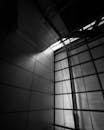 黑白图像以戏剧性的光影效果，捕捉了现代建筑的结构