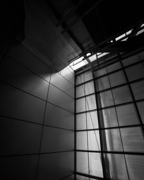 黑白图像以戏剧性的光影效果，捕捉了现代建筑的结构