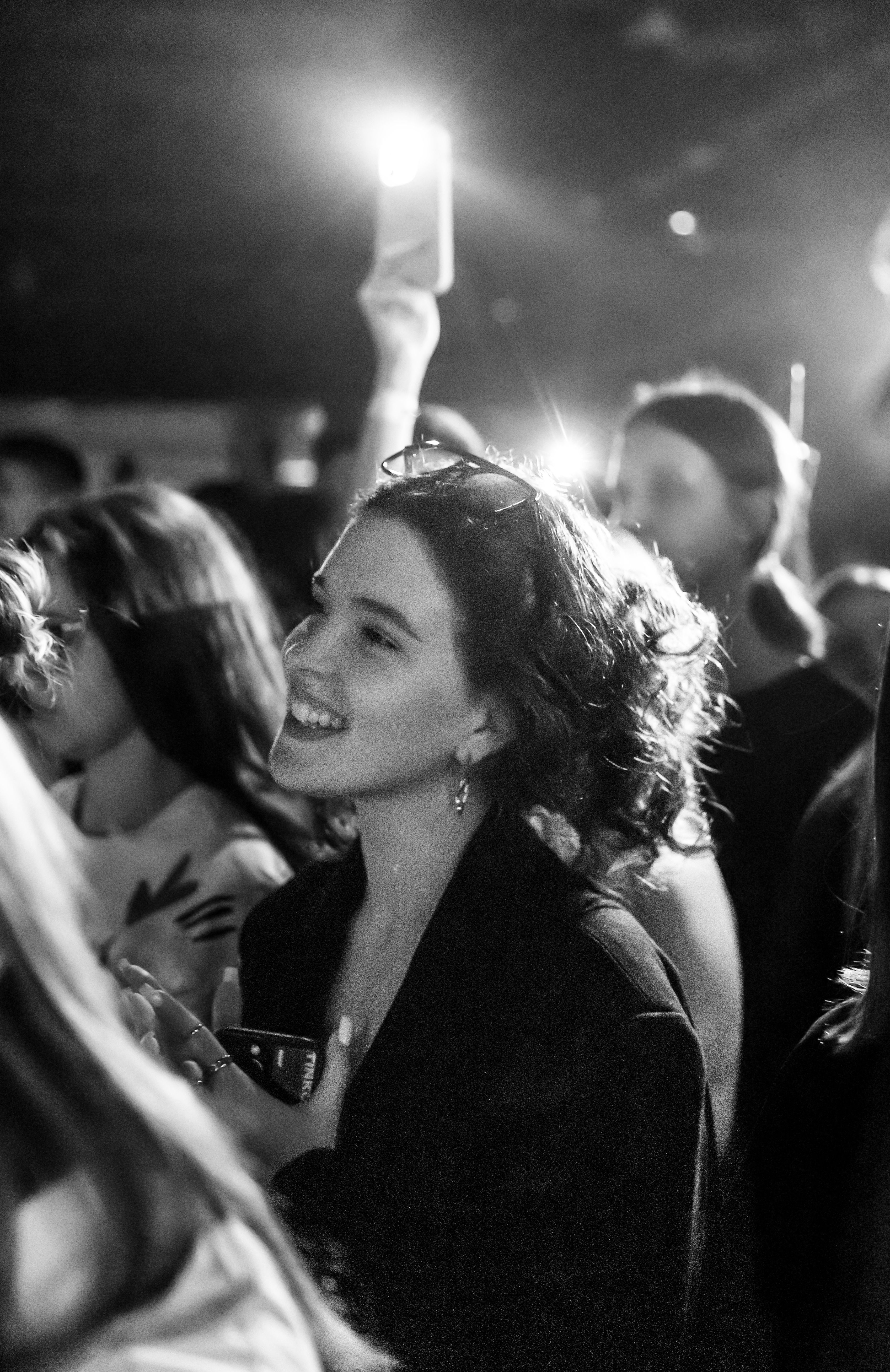 Black and white image of people enjoying a live concert, capturing the vibrancy and energy of the moment.