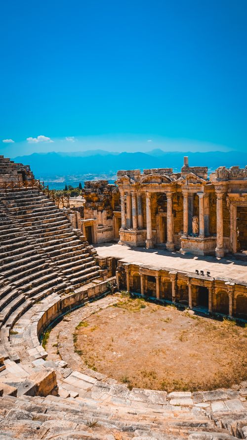 Free Discover the stunning ancient amphitheatre at Hierapolis in Pamukkale, Türkiye, under a vibrant blue sky. Stock Photo