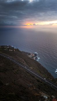A stunning sunset view over the coast of Tacoronte, Spain, featuring cliffs and ocean.
