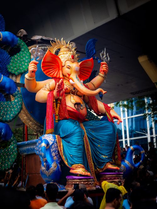 Free Colorful Lord Ganesha statue displayed during a lively street festival with a large crowd. Stock Photo