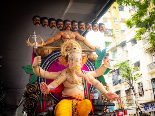 Free Vibrant statue of Lord Ganesh on display in a lively street festival scene. Stock Photo