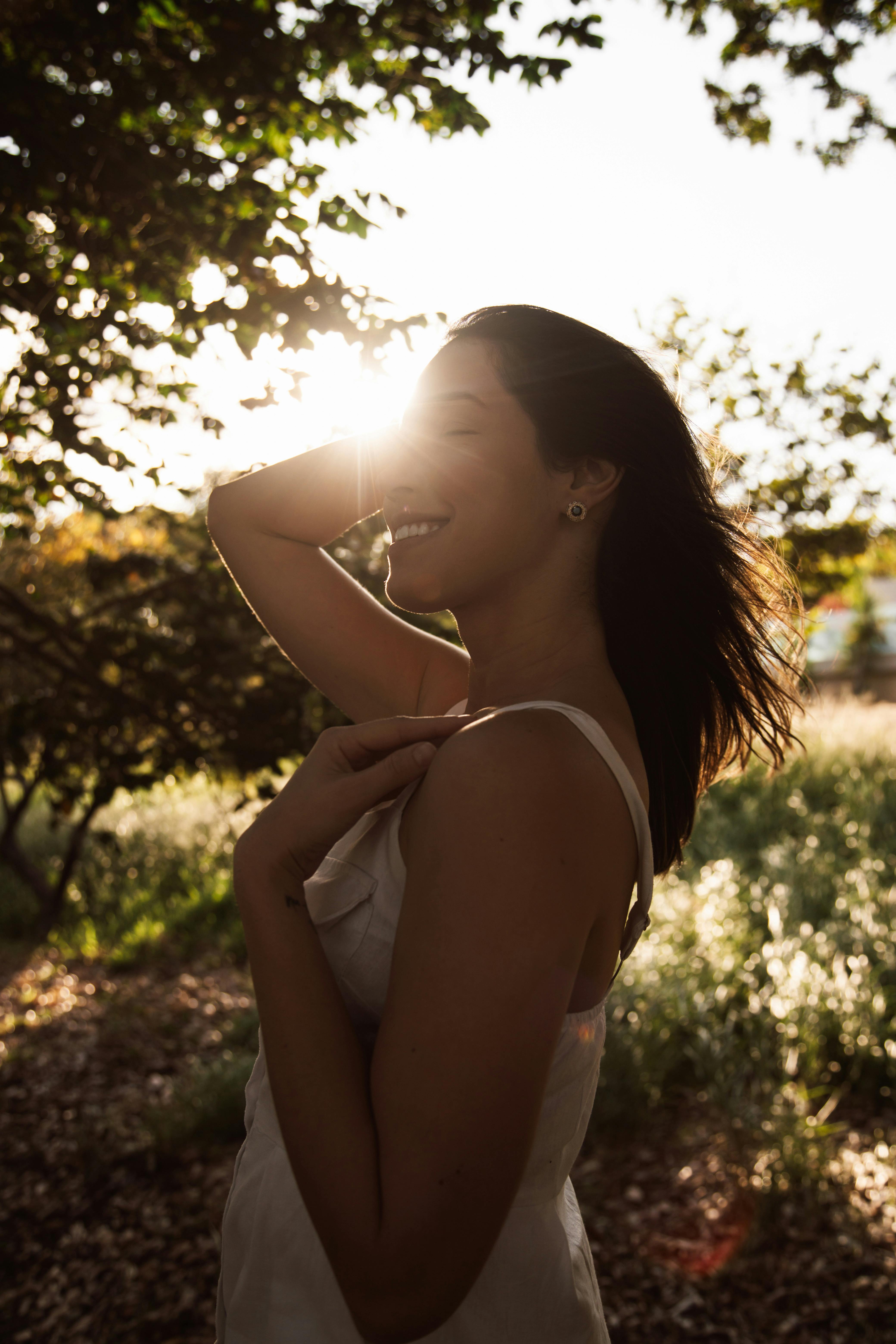 a woman is smiling in the sun