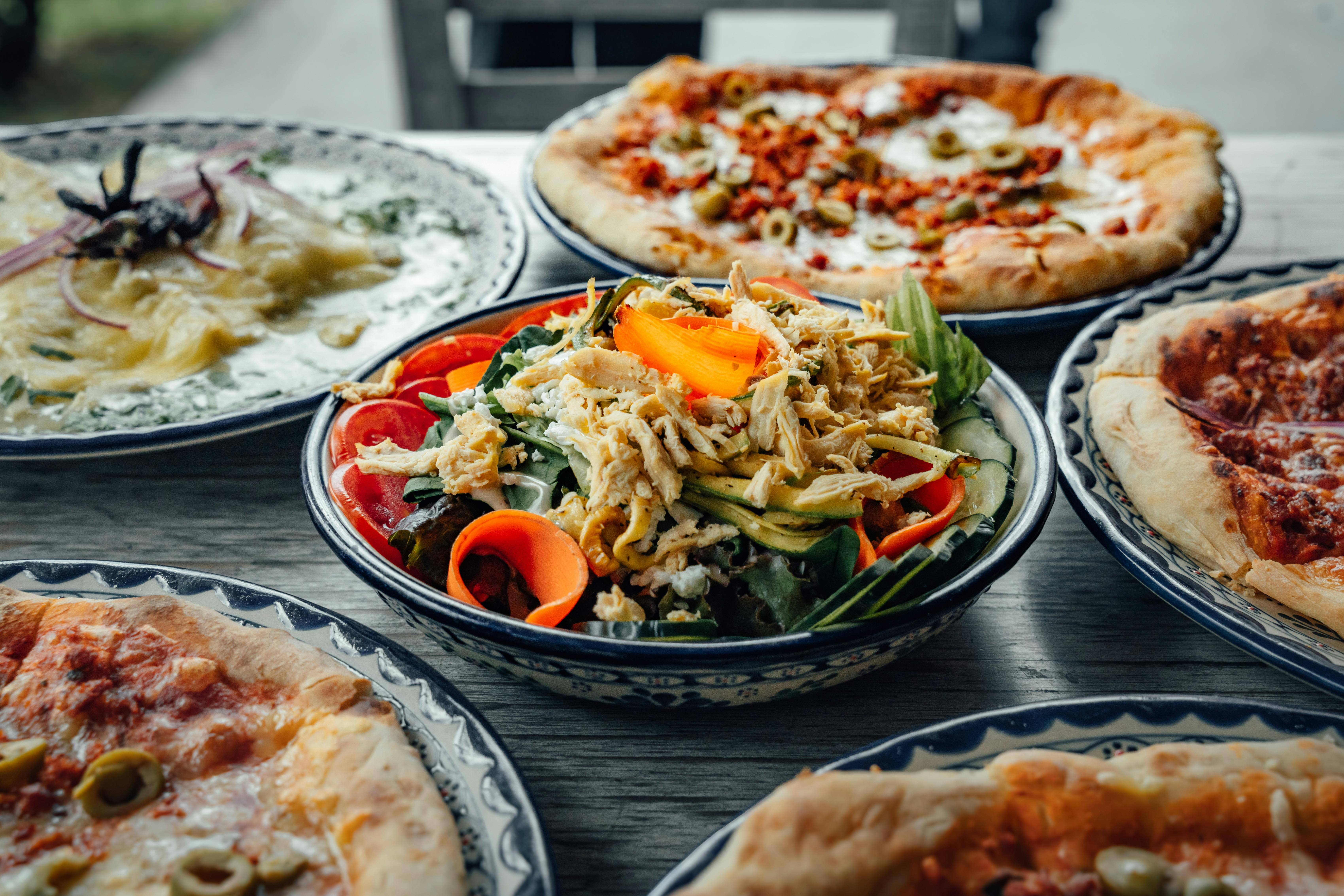 a table with several different types of pizza on it